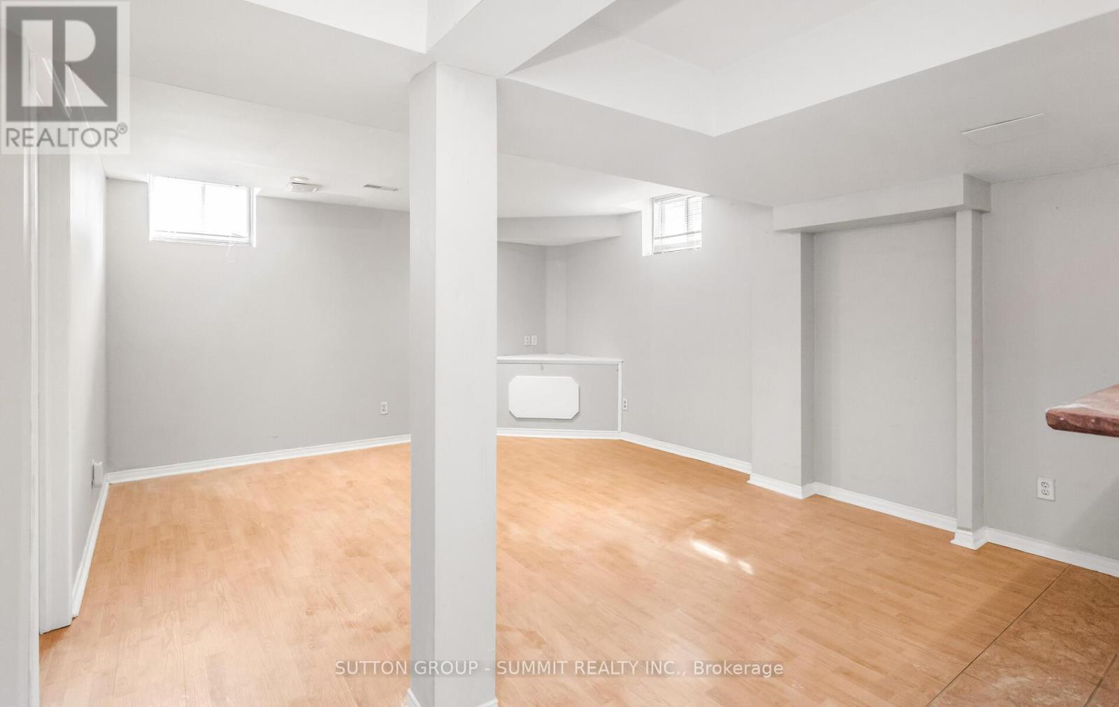 A room with wooden flooring and white walls.