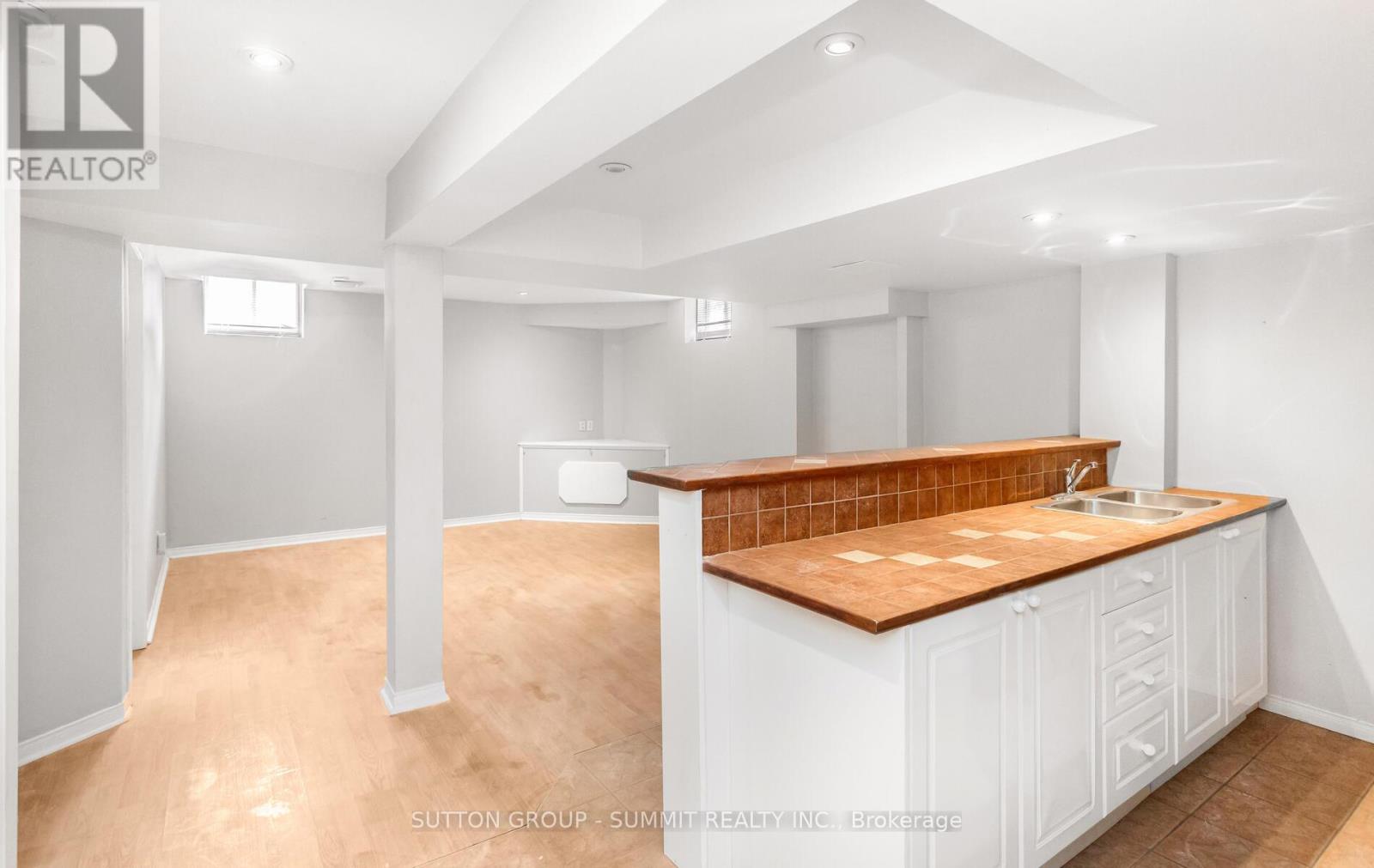 A kitchen with white cabinets and a wooden countertop.