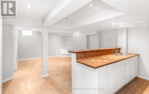A kitchen with white cabinets and a wooden countertop.