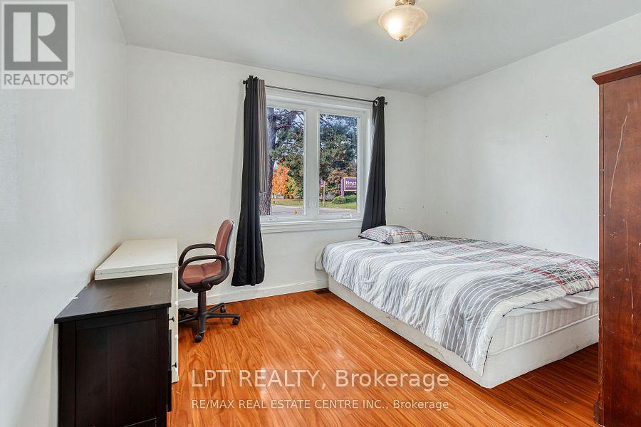 A bedroom with a bed, desk, and chair.