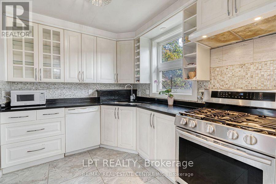 A kitchen with white cabinets and a black stove top.