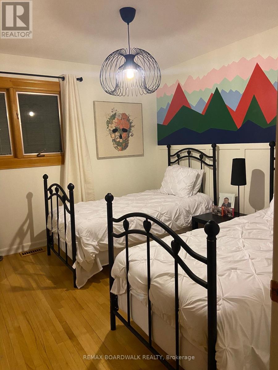 A bedroom with two beds and a mountain mural on the wall.