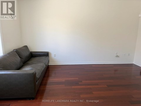 A living room with a couch and wooden floors.