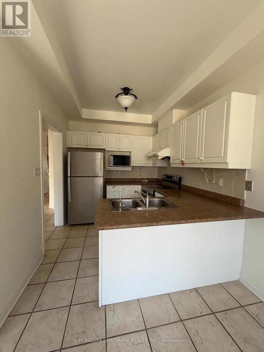A kitchen with white cabinets and a brown countertop.