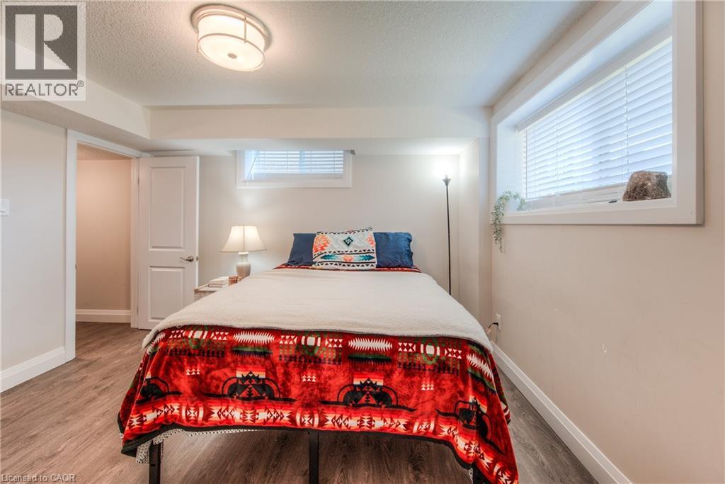A bedroom with a bed covered in a red and black patterned blanket.