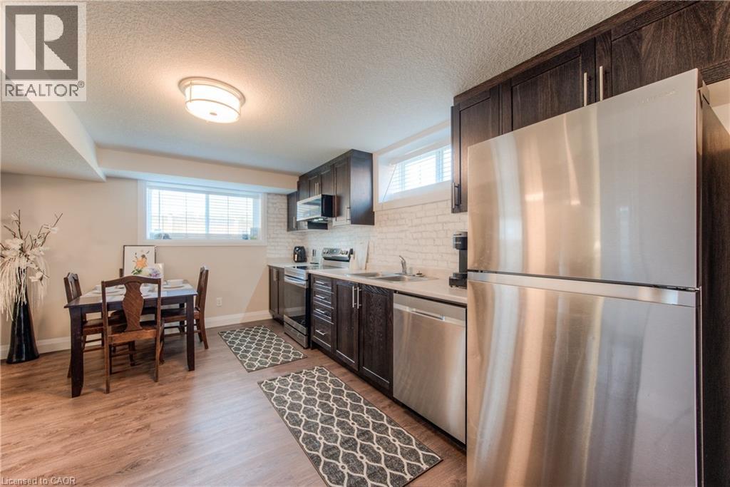 A modern kitchen with a wooden table and stainless steel appliances.