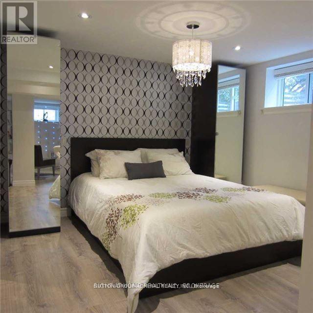 A bedroom with a large bed and a chandelier.