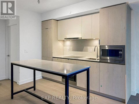 A kitchen with a table and a microwave oven.