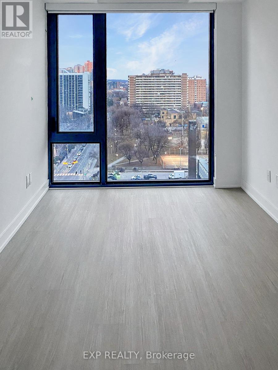 A large empty room with a view of the city through the window.