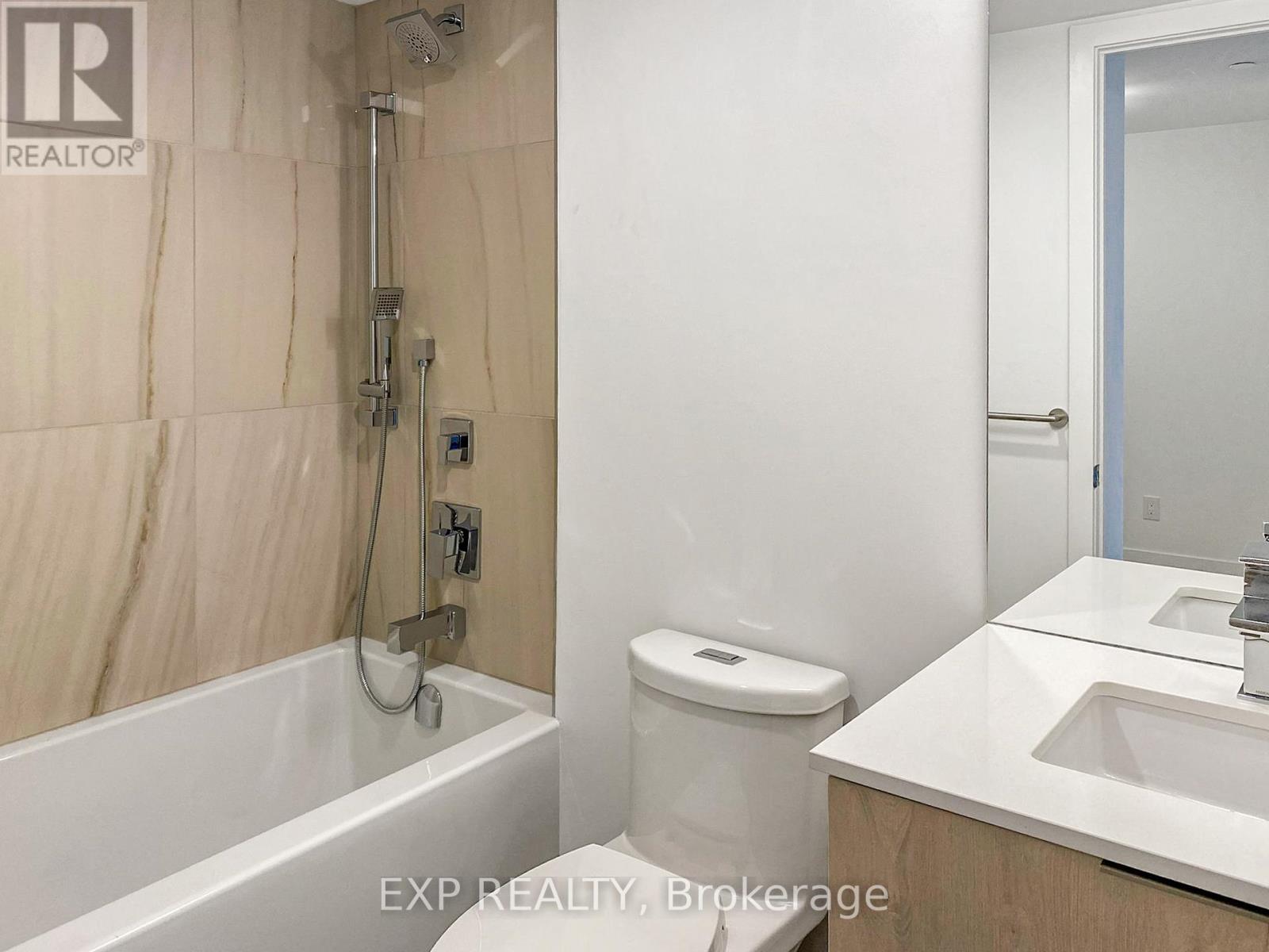 A bathroom with a tub, toilet, and sink.