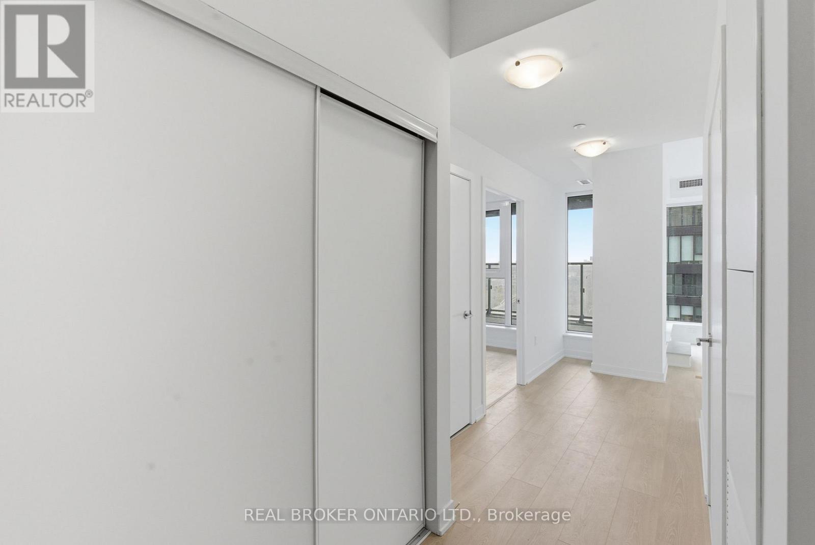 A white interior space with a sliding door and a Real Broker logo.