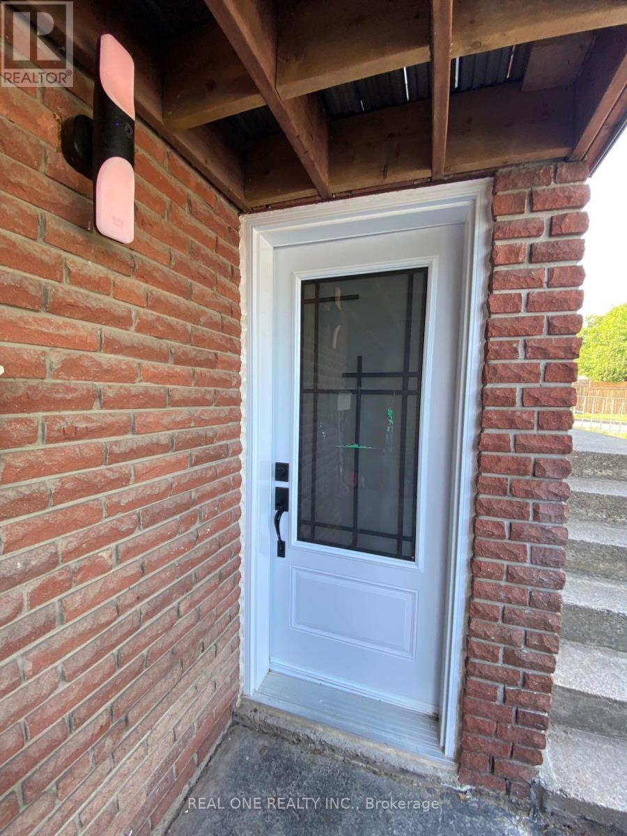 A white door with a glass window is set in a brick wall.