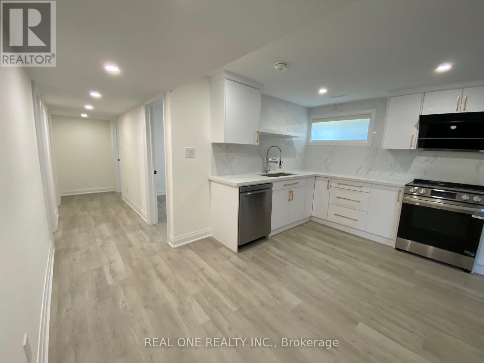 A modern kitchen with white cabinets and stainless steel appliances.