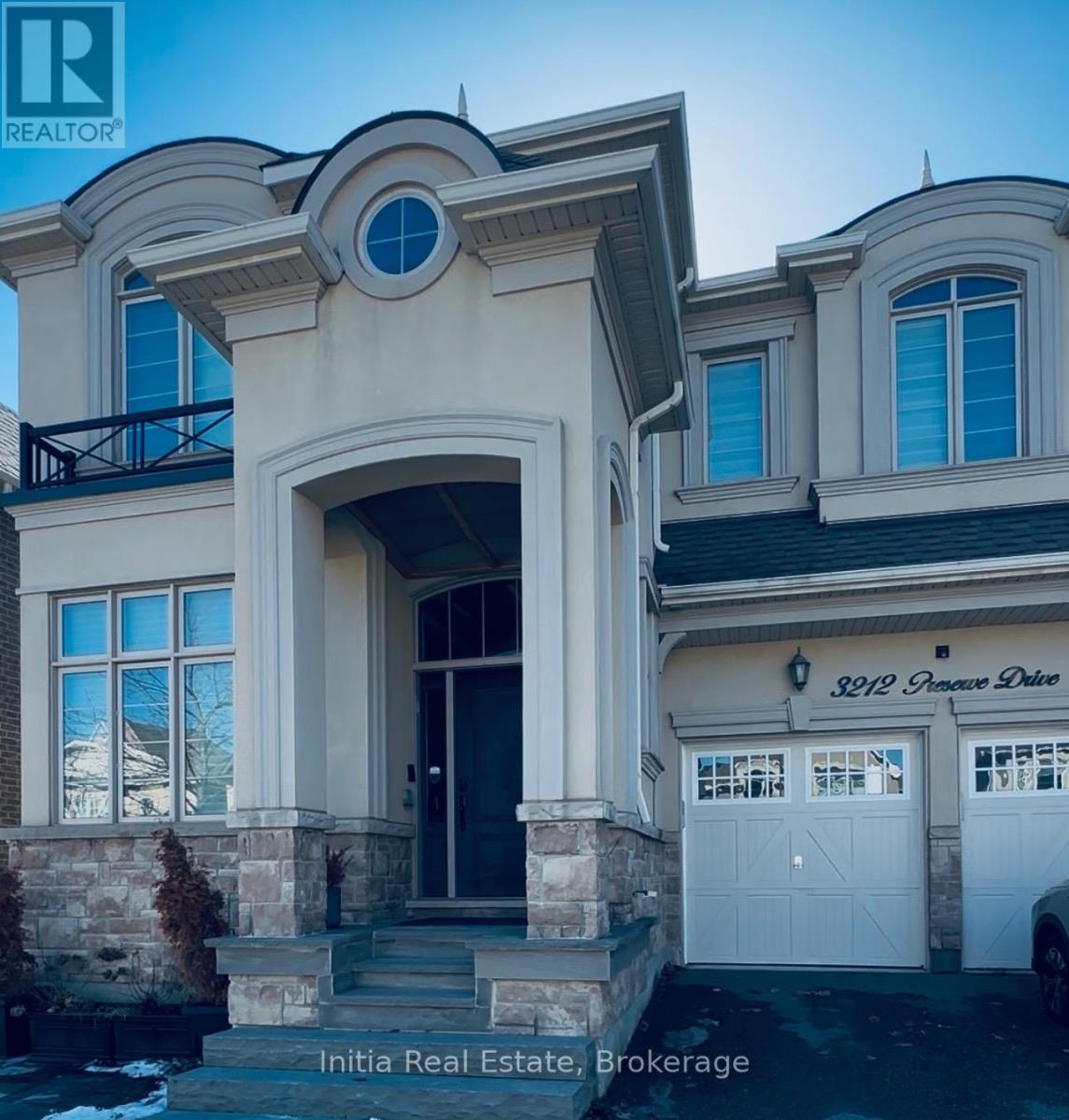 A house with a balcony and a large arched entrance.