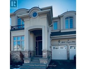 A house with a balcony and a large arched entrance.