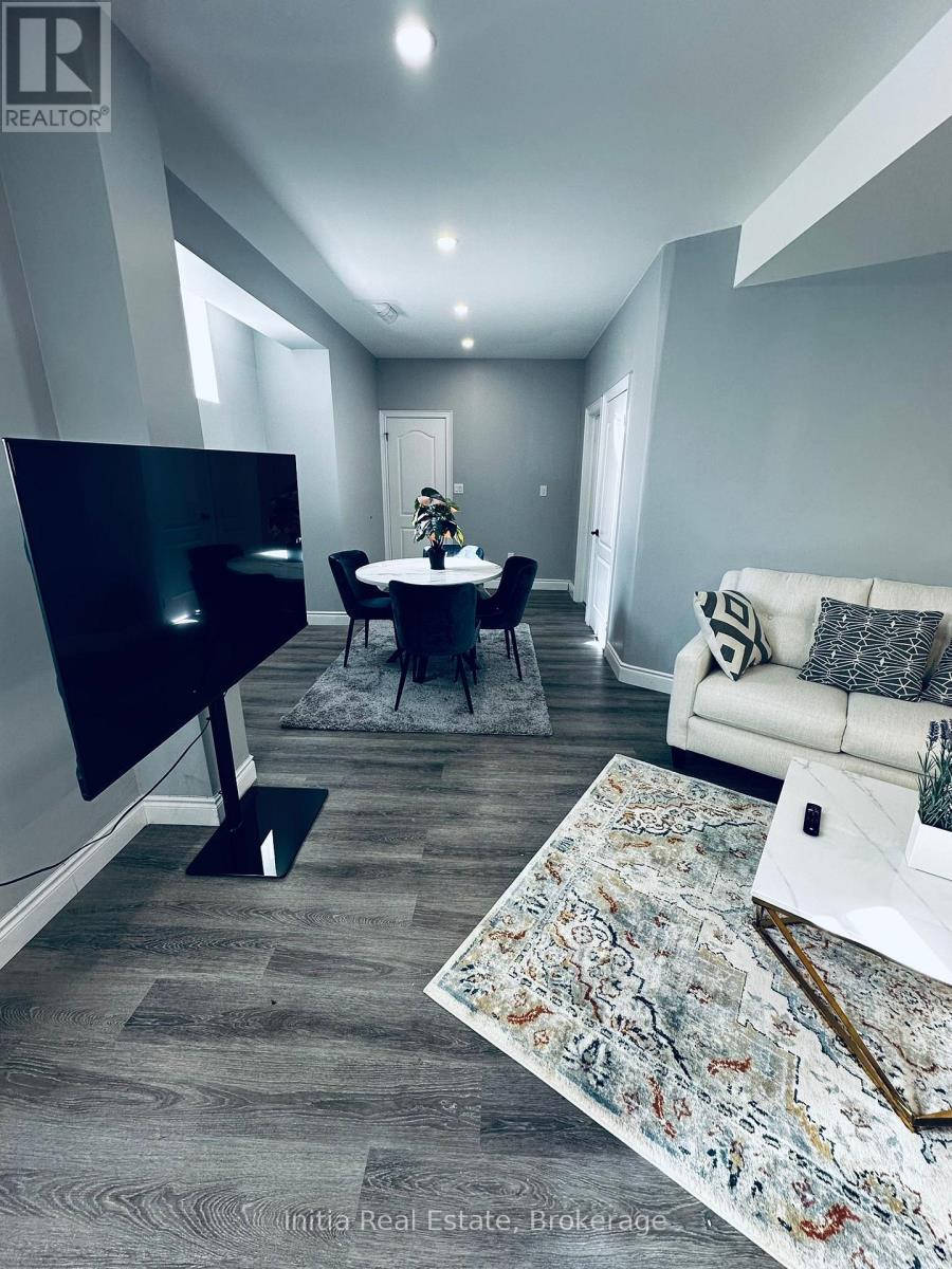 A living room with a black television and a grey sofa.
