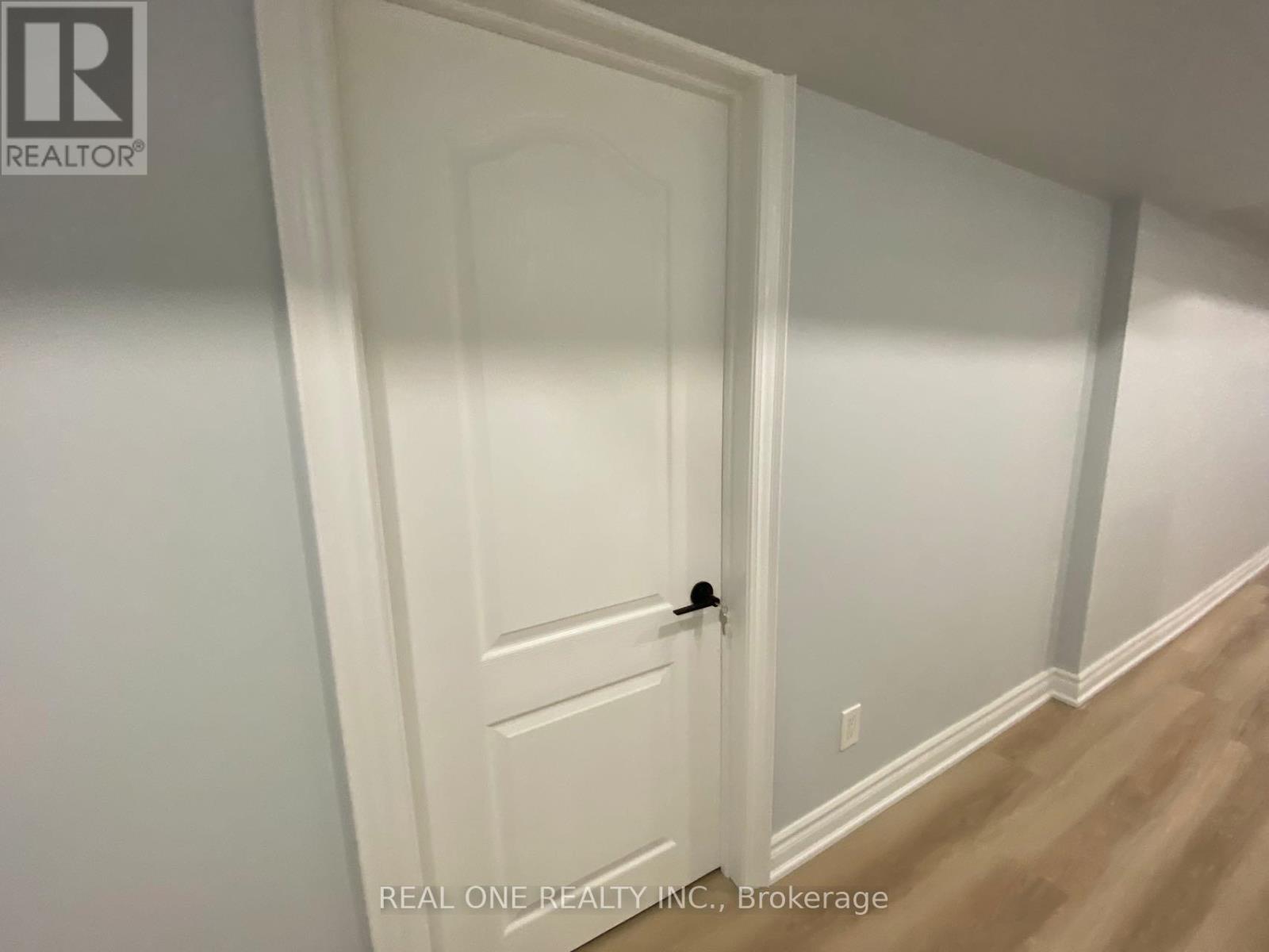 A white door with a black handle in a room with light colored walls.