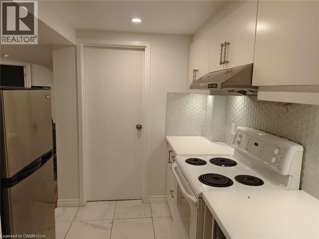 A kitchen with a white stove and a white door.