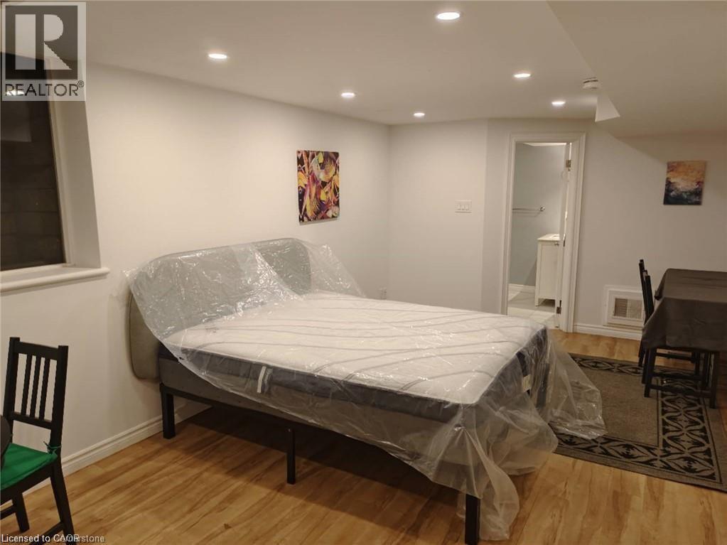 A bedroom with a bed covered in plastic and a chair.