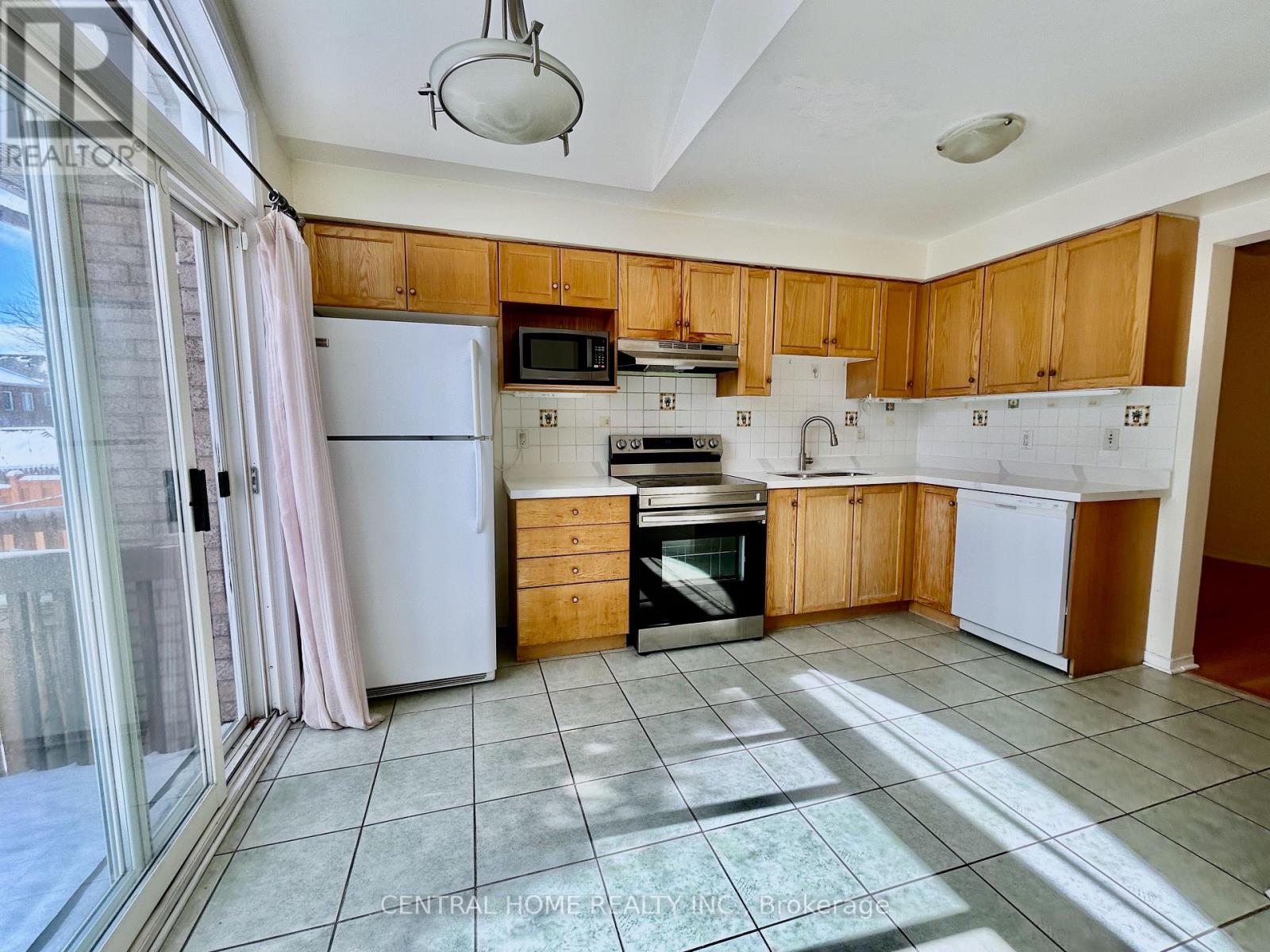 A kitchen with wooden cabinets and a white refrigerator.