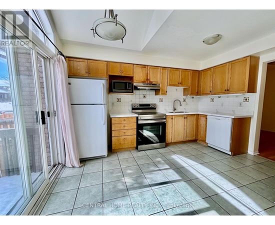 A kitchen with wooden cabinets and a white refrigerator.