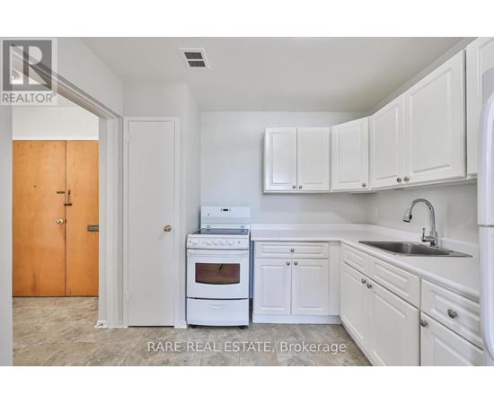 A kitchen with white cabinets and a white oven.