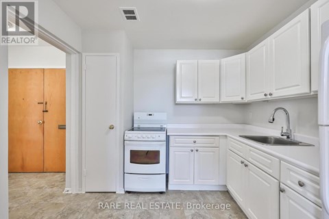 A kitchen with white cabinets and a white oven.