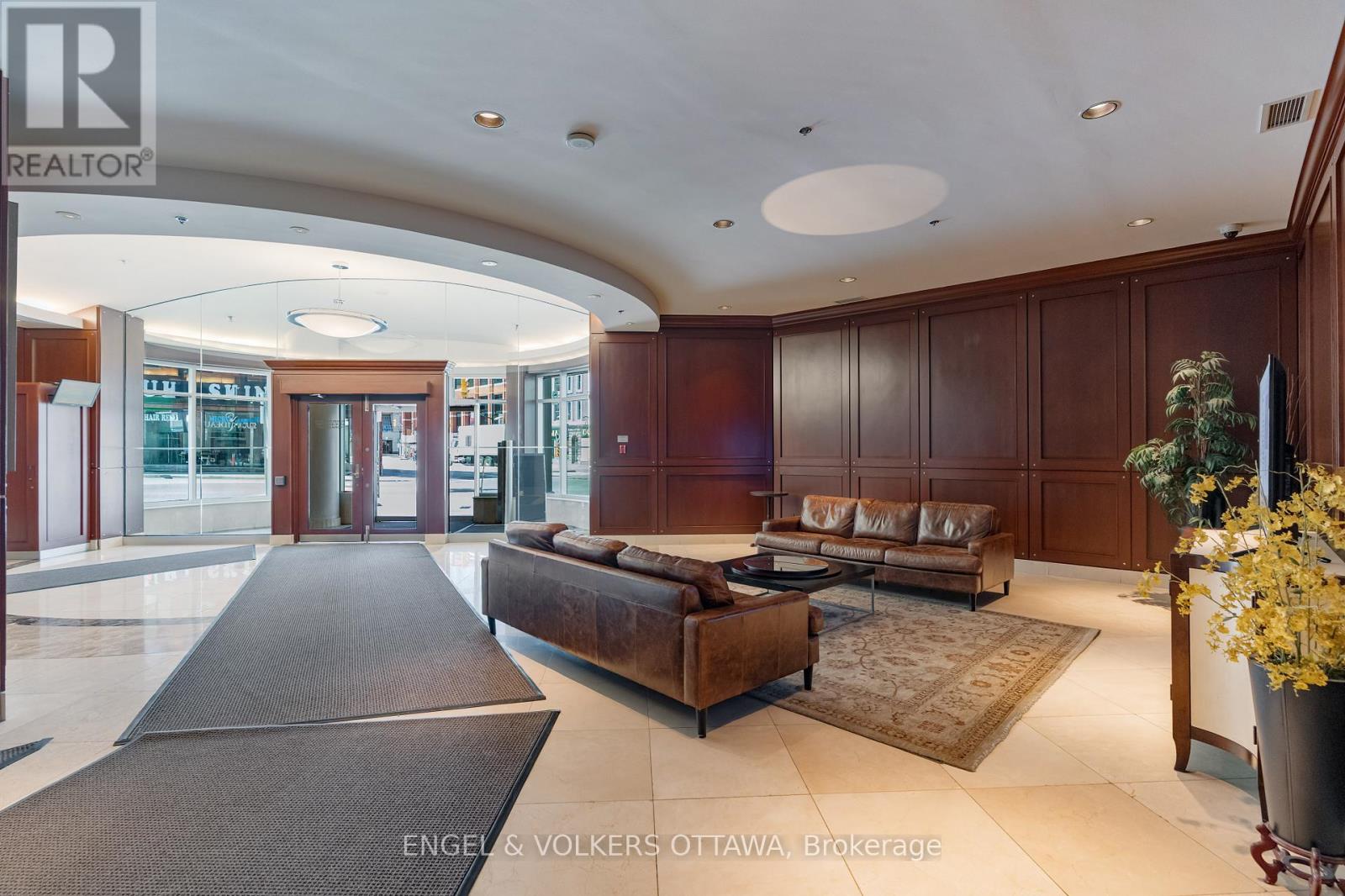 A large, well-lit living room with a long couch and a rug.