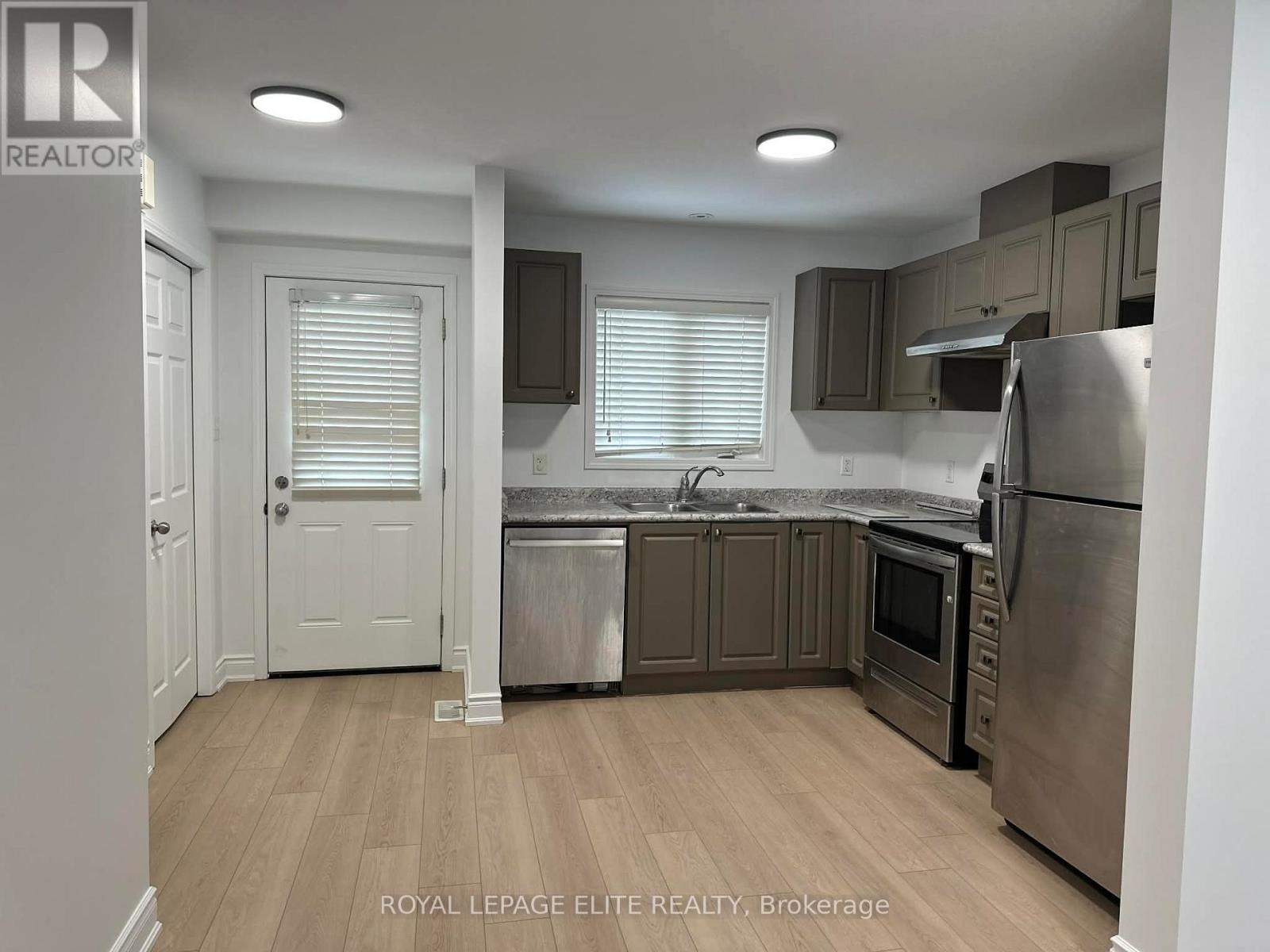 A kitchen with wooden floors and stainless steel appliances.