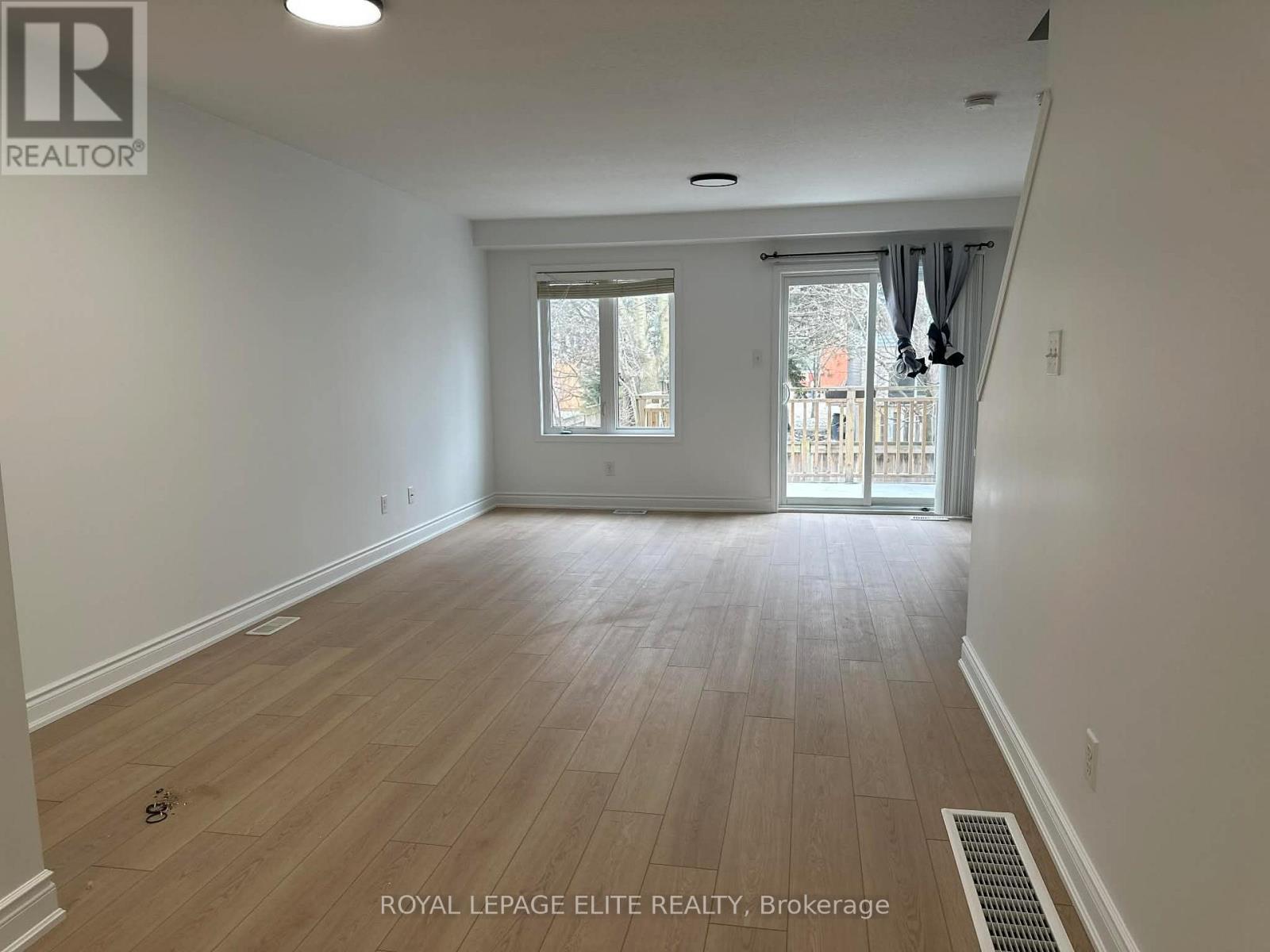 A room with wooden flooring and a sliding glass door.