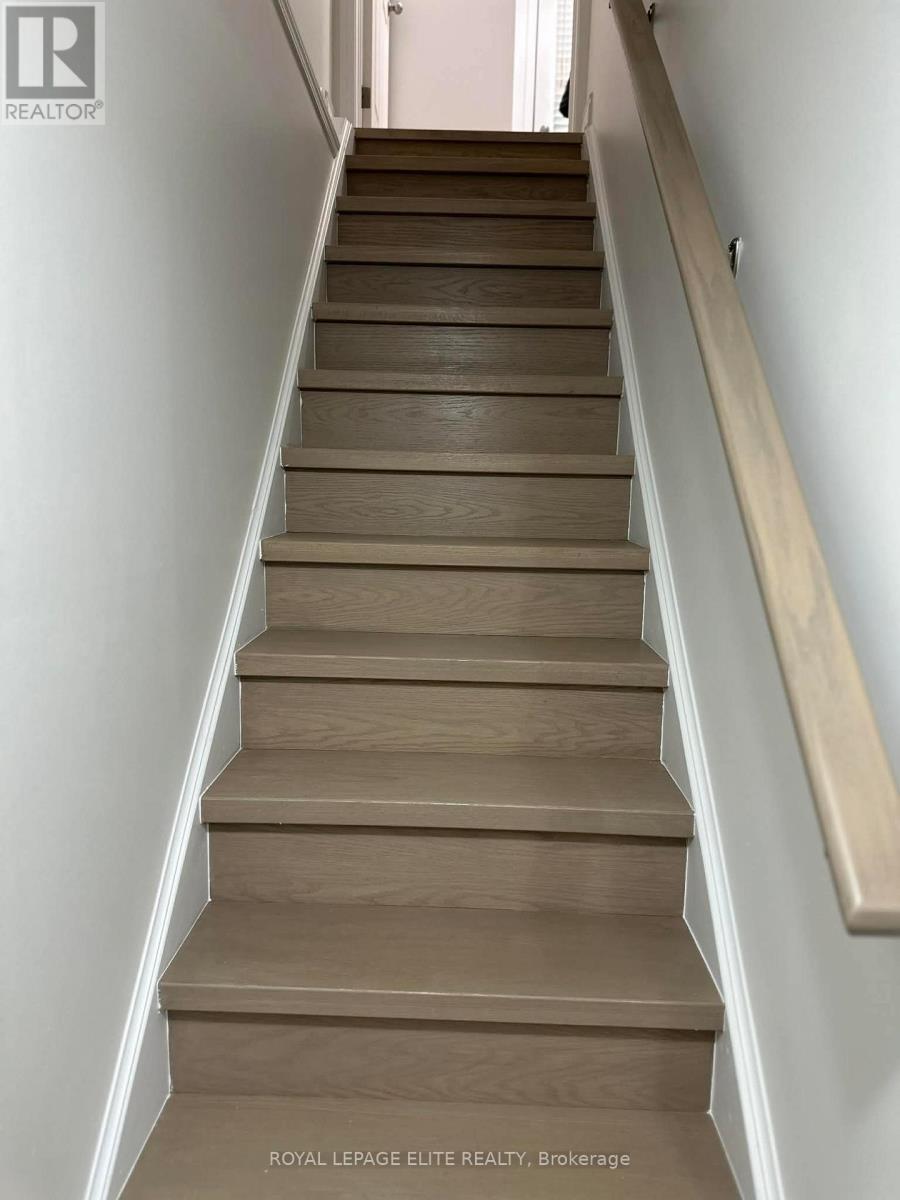 A set of stairs with a wooden handrail.