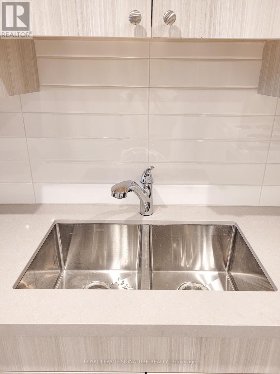 A modern kitchen with a double sink and a shelf above it.