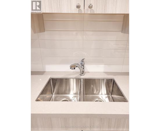 A modern kitchen with a double sink and a shelf above it.