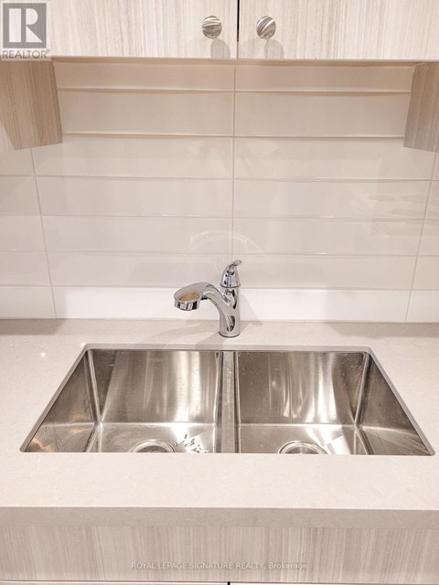 A modern kitchen with a double sink and a shelf above it.