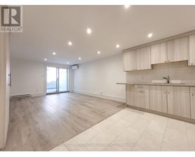 A spacious room with wooden flooring and white walls.