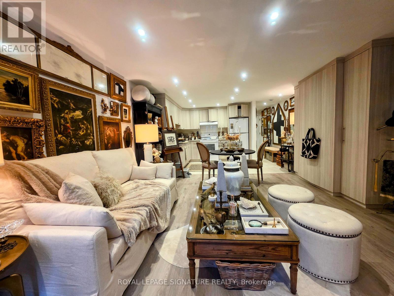 A well-lit, spacious living room with a white sofa, wooden coffee table, and a variety of decorative items.