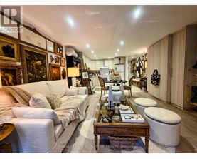 A well-lit, spacious living room with a white sofa, wooden coffee table, and a variety of decorative items.
