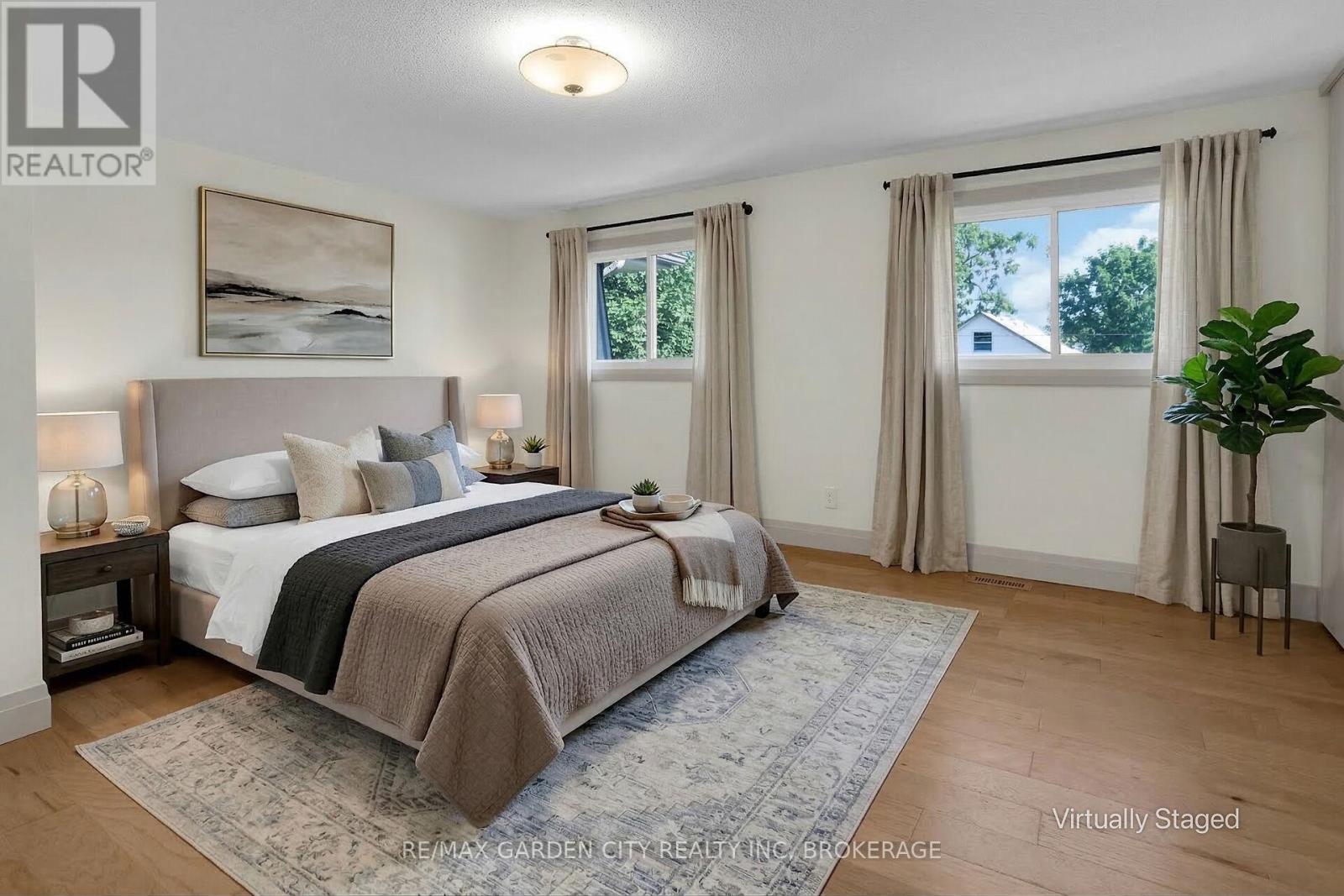 A bedroom with a large bed and a painting on the wall.