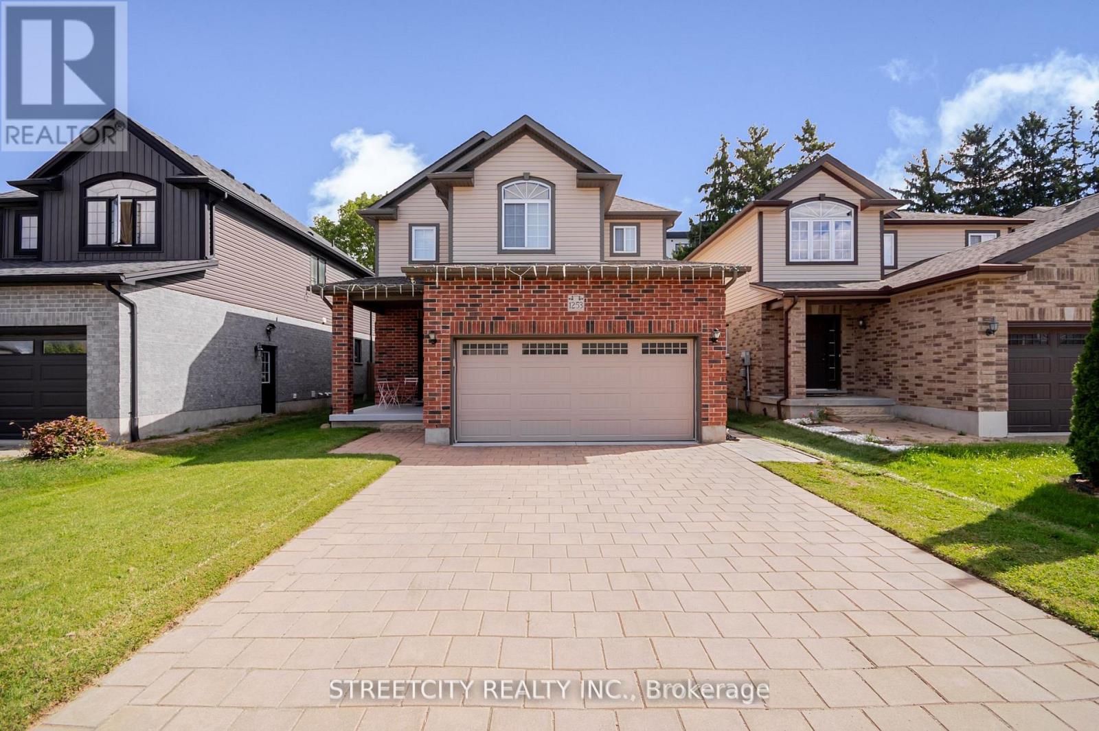 A house with a brick wall and a garage door is for sale in Brokerage.