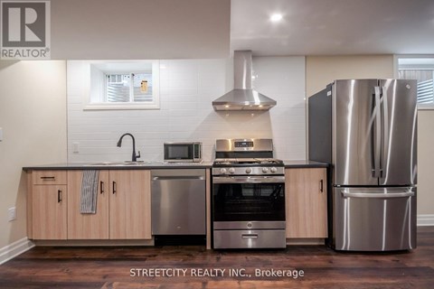 A modern kitchen with wooden cabinets and stainless steel appliances.