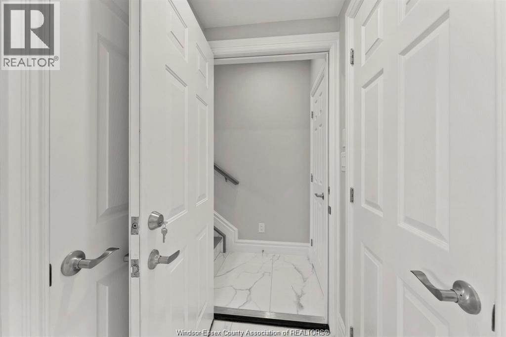 A hallway with white doors and a marble floor.