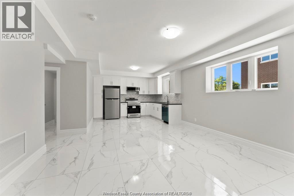 A spacious kitchen with white marble flooring and modern appliances.