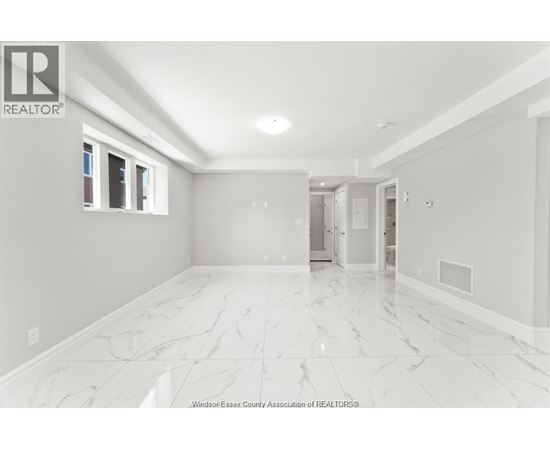 A spacious room with marble flooring and white walls.