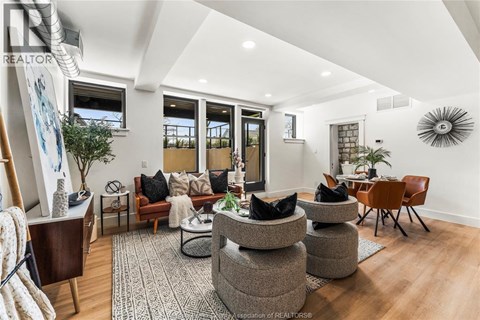 A living room with a grey rug and a brown chair.
