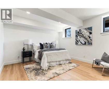 A bedroom with a bed, nightstand, and chair.