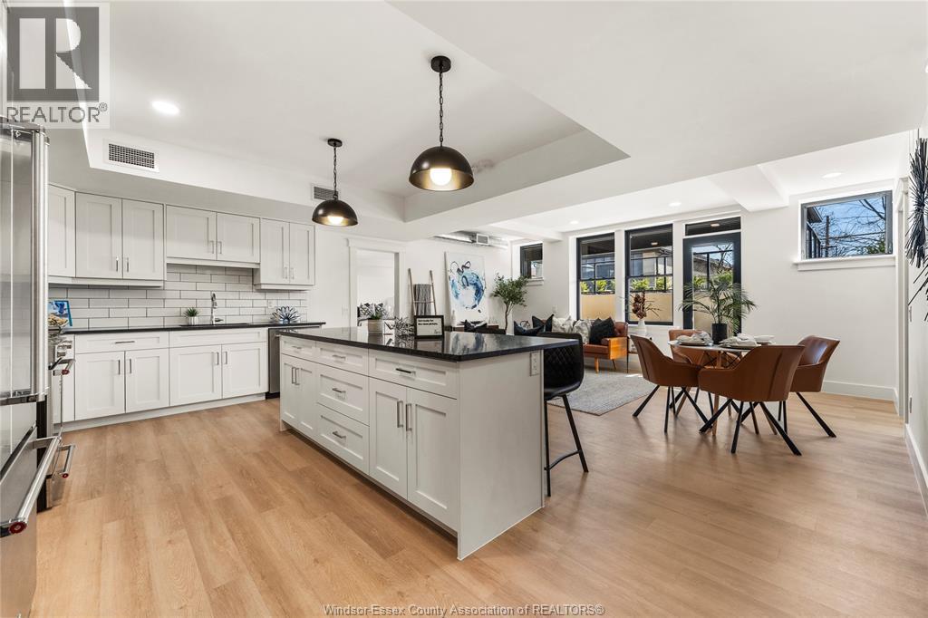 A kitchen with white cabinets and a wooden floor.