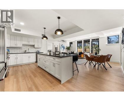 A kitchen with white cabinets and a wooden floor.