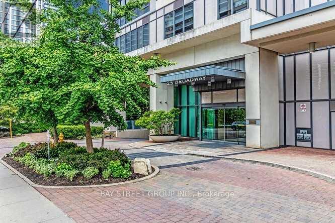A tree in front of a building with a sign that says Bay Street Group Inc. Brokerage.