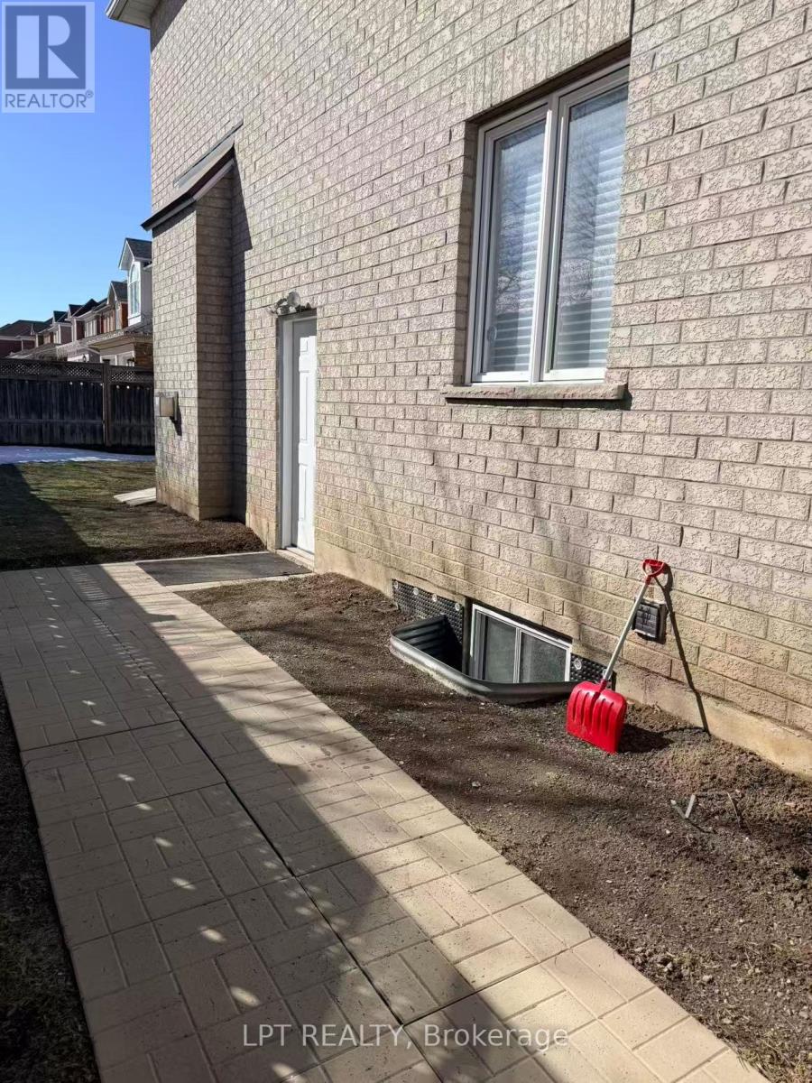 A red object is sticking out of a ditch in front of a brick wall.