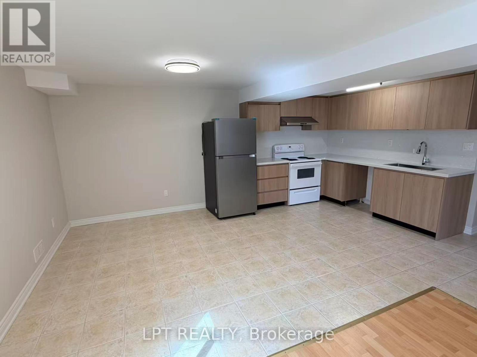 A kitchen area with a refrigerator, microwave, and sink.